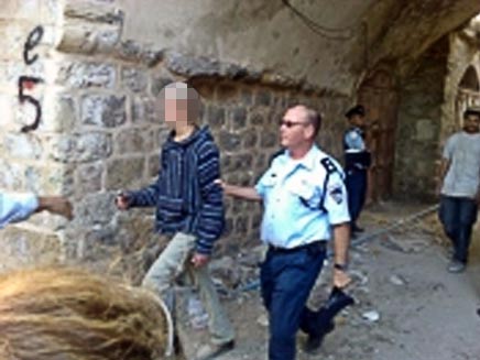 שוטר מלווה מתנחל צעיר - בית הויזמן חברון (תמונת AVI: עמיחי אתאלי, חדשות)